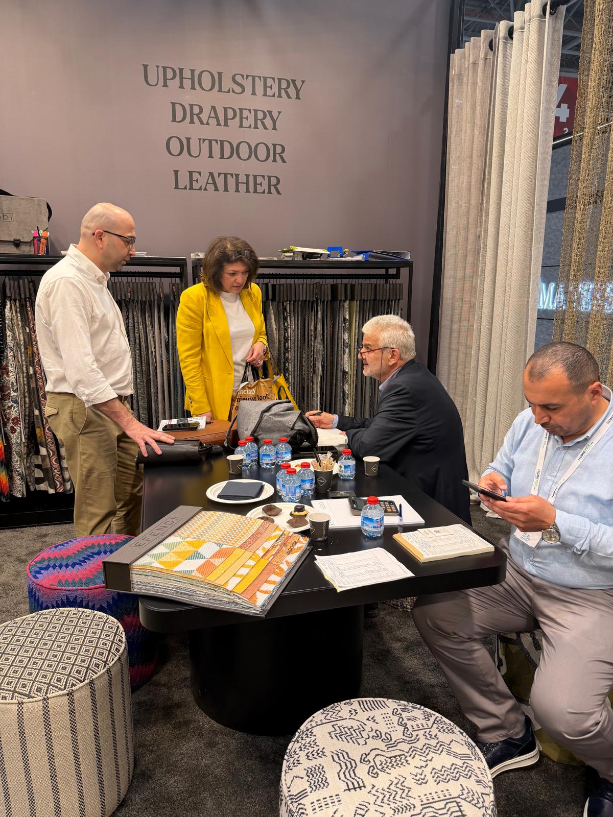 Business meeting around upholstery, drapery, outdoor fabrics and leather samples at HOMETEX 2026